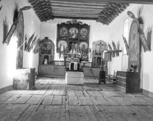 John Collier Jr. (1913 - 1992). A church which was built in 1700 and is the best-preserved colonial mission in the Southwest. Symbolic coffin placed in readiness for a memorial mass. Trampas, New Mexico. January 1943.