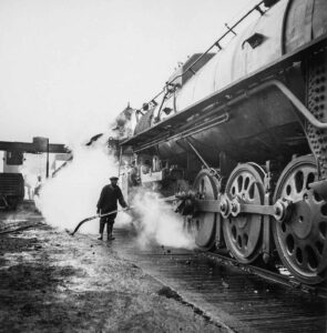 Jack Delano (1914 - 1997). Washing a locomotive at the coaling station at an Illinois Central railroad yard. Chicago, Illinois. November 1942.