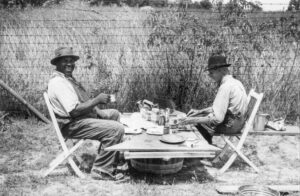 Marion Post Wolcott (1910 - 1990). A stable hand and a trainer eating a picnic lunch before the Shelby county Horse show and fair. Shelbyville, Kentucky. August 1940.