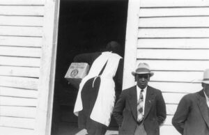 Marion Post Wolcott (1910 - 1990). Two men who are attending a meeting of ministers and deacons which is being held at a Negro church. Yanceyville (vicinity), North Carolina. October 1941.