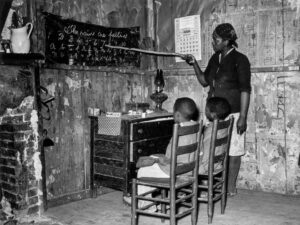 Russell Lee (1903 - 1986). Negro mother teaching children numbers and alphabet in home of sharecropper. Transylvania, Louisiana. January 1939.
