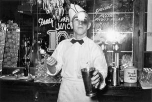 Russell Lee (1903 - 1986). Soda jerker flipping ice cream into malted milk shakes. Corpus Christi, Texas. February 1939. Gift of D&C Camera, Salinas, CA.