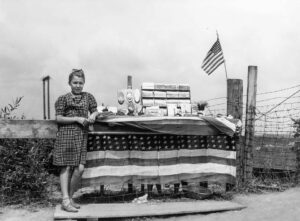 John Vachon (1914 - 1975). Girl who sells pieces of ore and iron range souvenirs to tourists. Hibbing, Minnesota. August 1941.