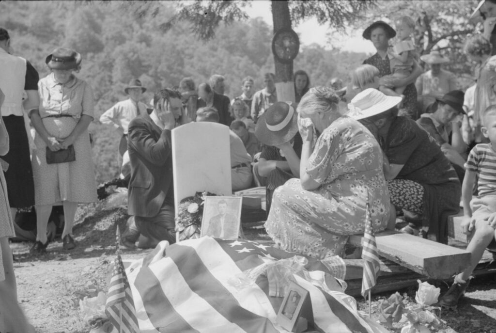 Marion Post Wolcott (1910 - 1990). The mother and other relatives of the deceased weeping at the grave at a memorial meeting. The preacher, with his hands over his ears, is praying. Jackson (Vicinity), Kentucky. August 1940.